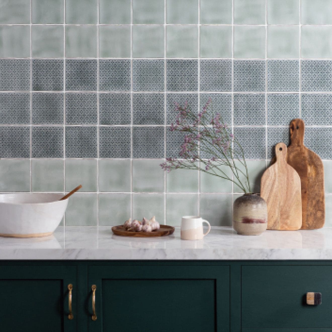A ceramic vase with a speckled gray and beige finish holding dried flowers in mint field tile design