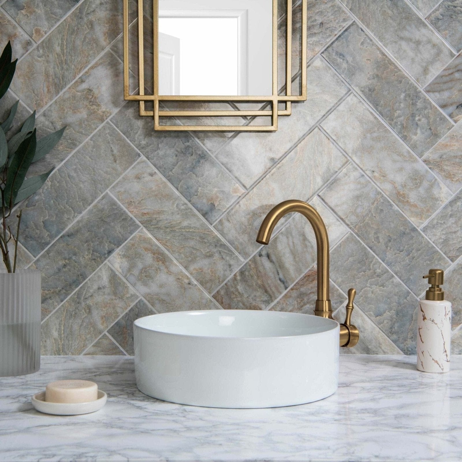 Onix Verde grey and beige marble-effect tiles with a vessel sink and gold tap