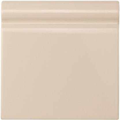Ivory skirting tile made of cream-colored ceramic with a smooth glossy finish and subtle horizontal ridges on top edge