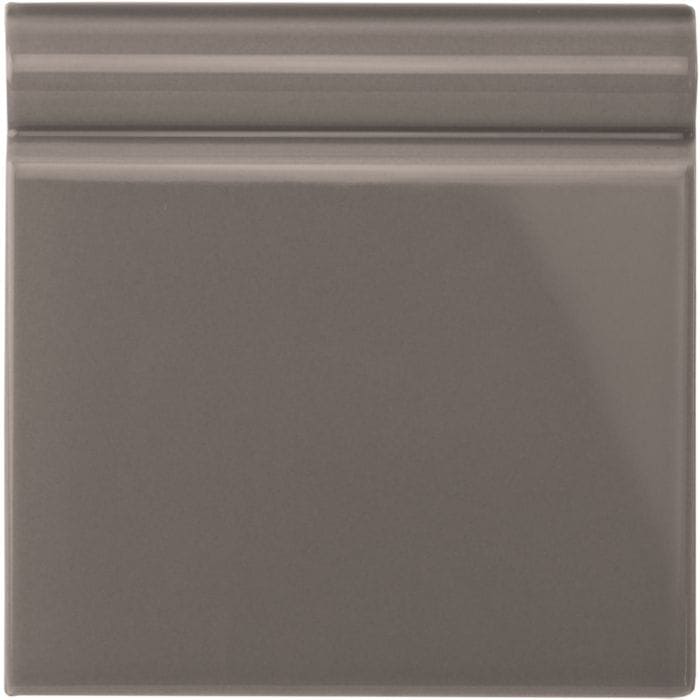 Gray london stone skirting tile with smooth glossy ceramic finish and subtle horizontal ridges on the top edge