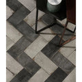 Osterley porcelain white brick dark gray and light gray rectangular stone tiles arranged in a herringbone pattern