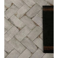Gray concrete-effect herringbone porcelain tile flooring with subtle weathered texture in osterley porcelain white brick style