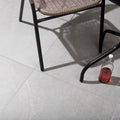Pulse Grey Tiles grey stone-effect paving with a glass bottle
