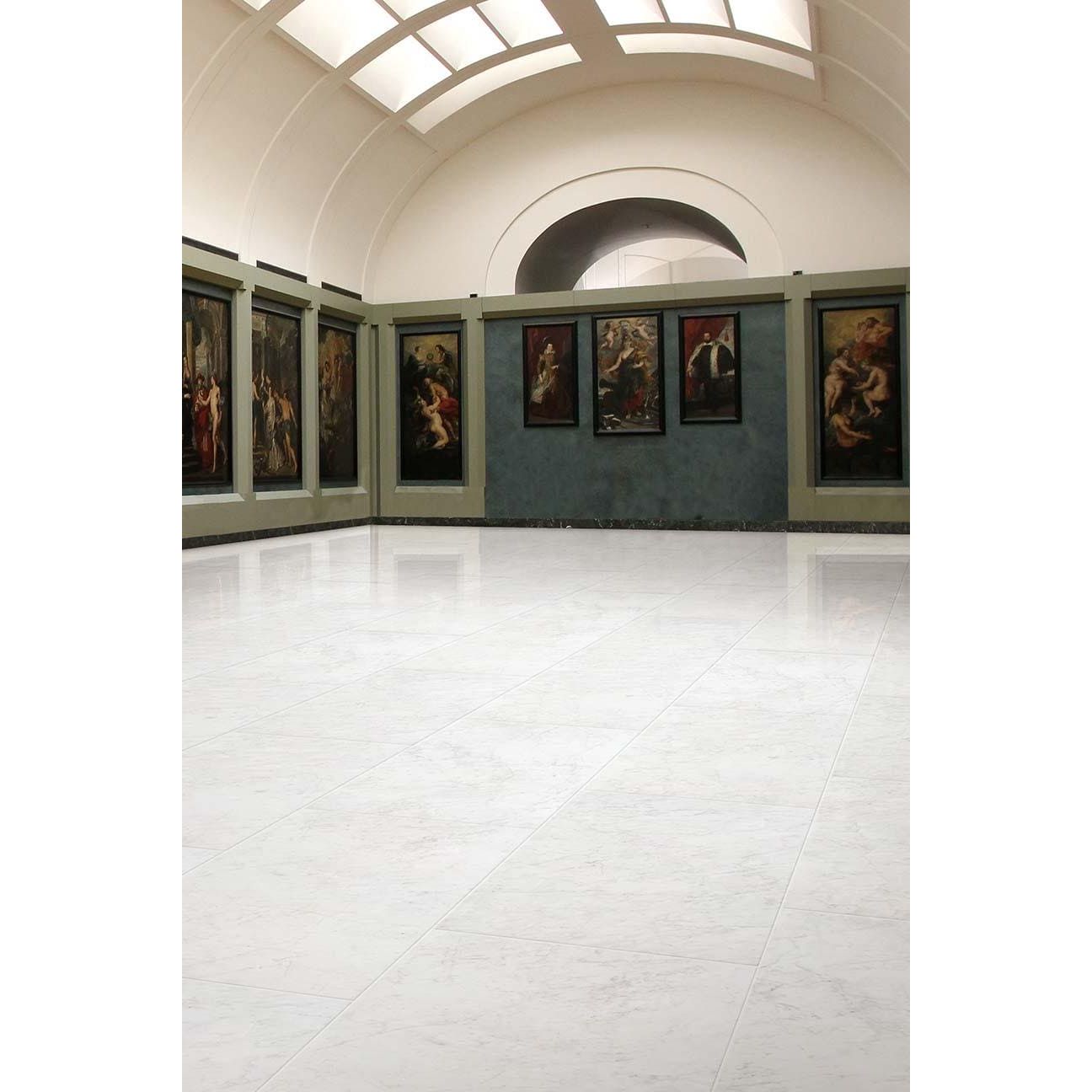 A series of framed classical paintings displayed on a curved gallery wall featuring python carrara porcelain gloss tiles