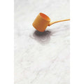 Python Carrara Porcelain Gloss white marble-effect tiles with a mustard wooden ladle
