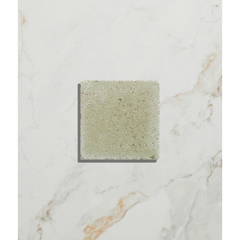 Square textured reform composite stone tumbled concrete tile in muted sage green finish called mint