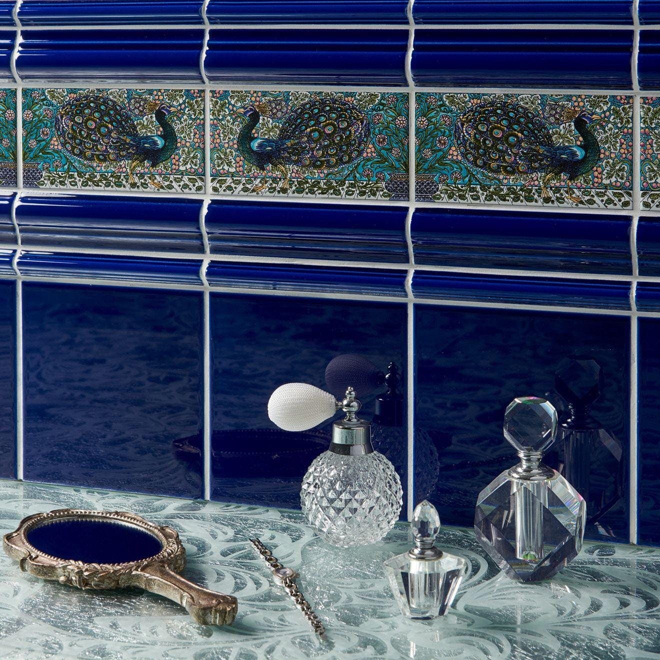 A vintage-style compact mirror with silver handle ornate gilded frame and royal blue reflective surface