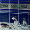 A vintage-style compact mirror with silver handle ornate gilded frame and royal blue reflective surface