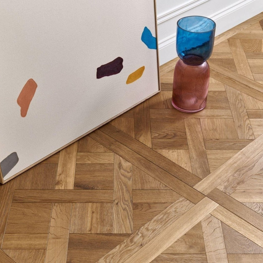 Colorful abstract painting leaning against a wooden wall with a glass of water on a parquet floor in Woodpecker Sandringham Royal Oak Design Panels.