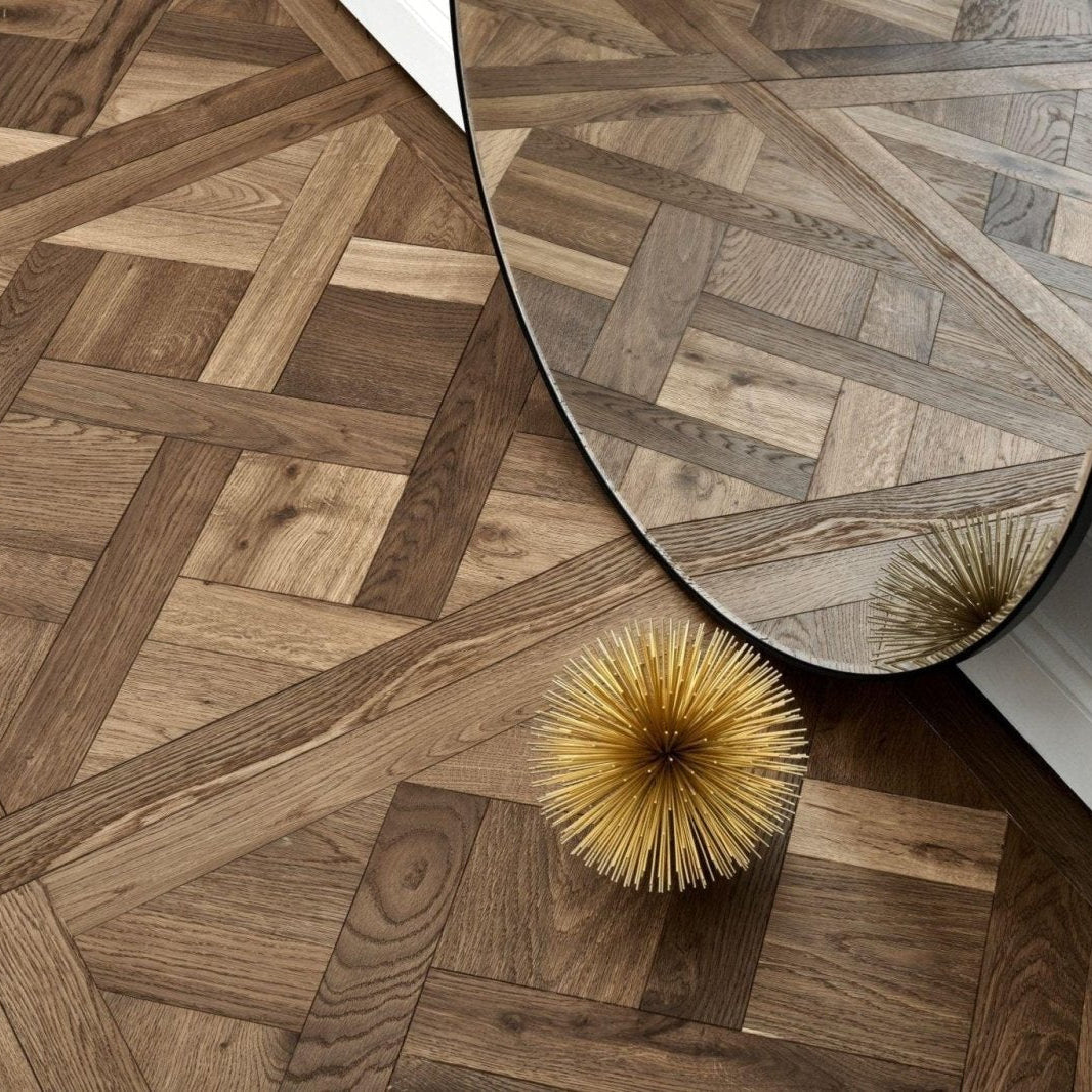 Wooden floor with a geometric pattern in Woodpecker Sandringham Royal Oak Design Panels and a decorative plant.