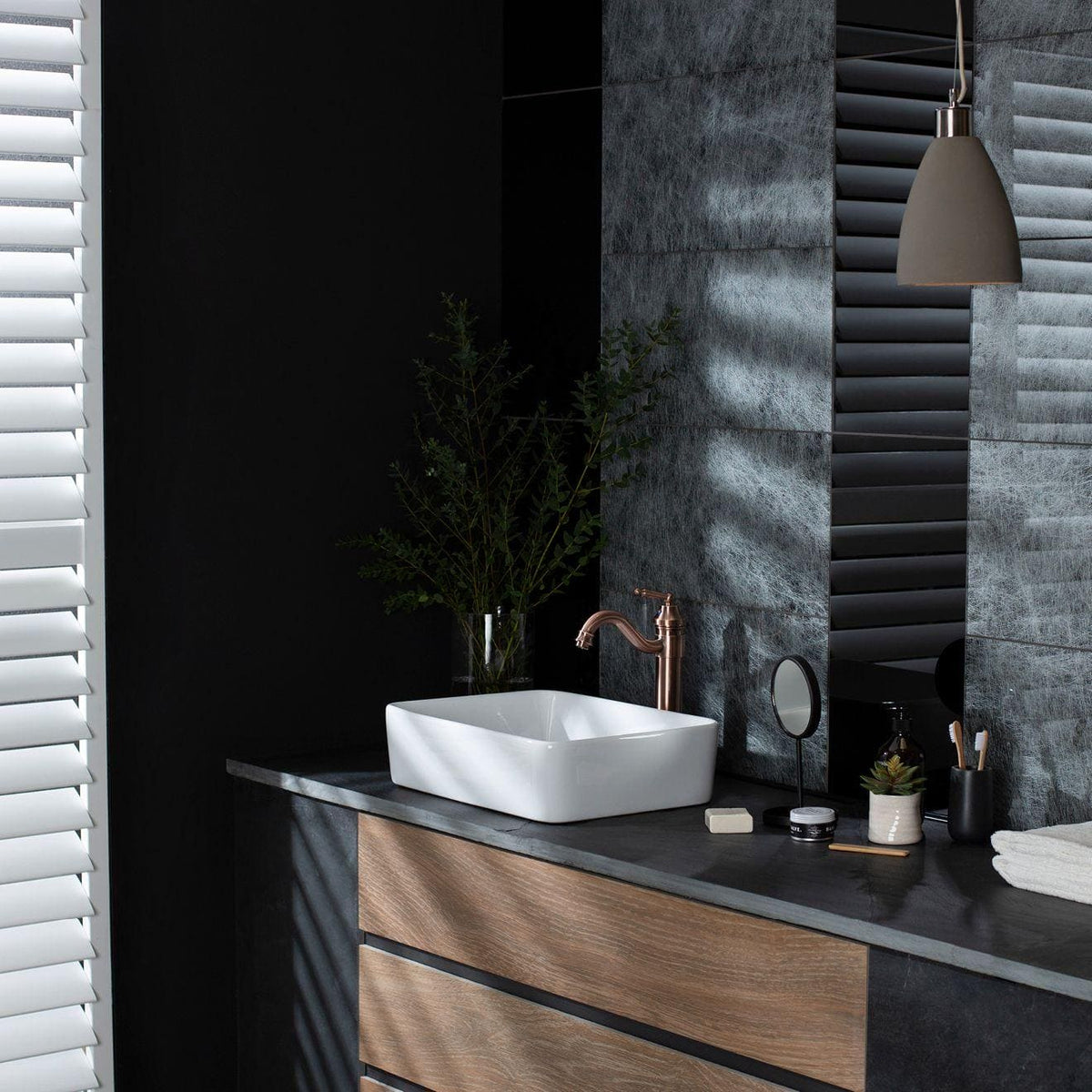 Spun Silk Silver on Black dark grey silver glass tiles with a sink and copper tap
