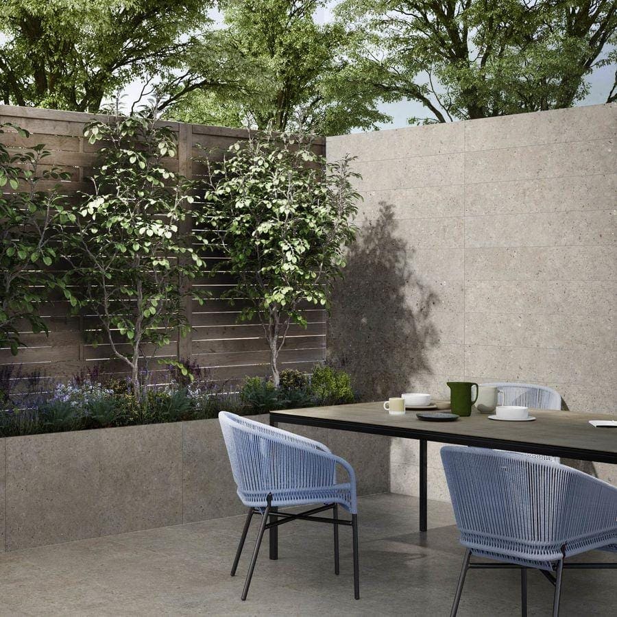 Light blue woven wicker patio chairs with black metal frames on terrazzo coolstone greige tiles