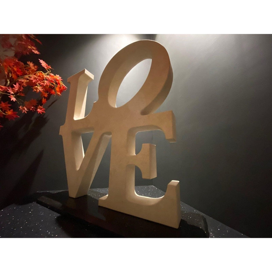 Beige wooden love sculpture decor with smooth matte finish and clean cut edges for stylish home display