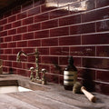A dark amber glass pump bottle with black cap and white minimalist label on a rustic countertop in tor brick tile