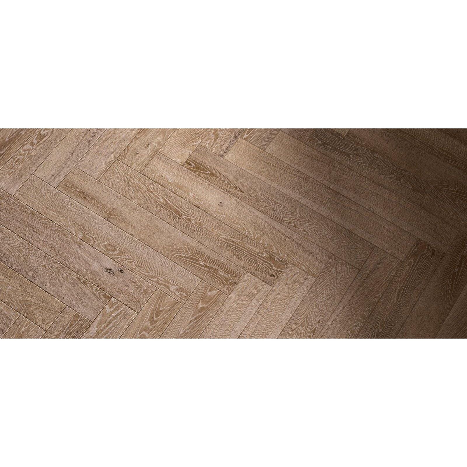 Light brown hardwood floor planks in a herringbone pattern from tree-charme beige matt collection