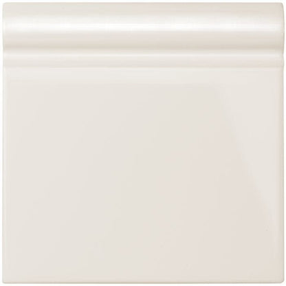 Vintage white skirting tile featuring cream-colored glossy ceramic baseboard trim for elegant wall finishing